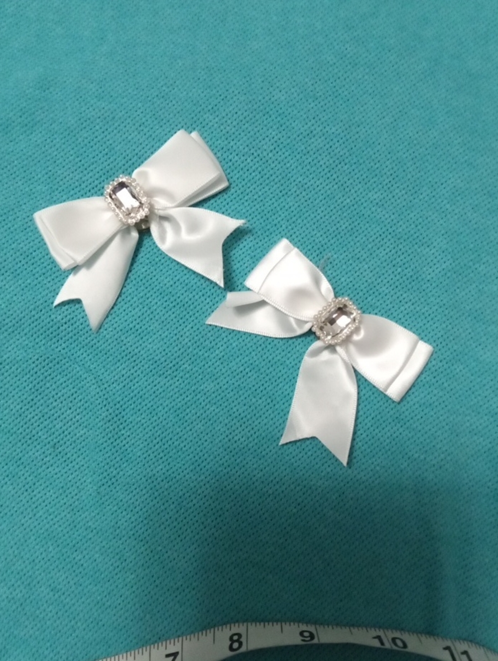 Two White Bows That Are A Pin On One Side